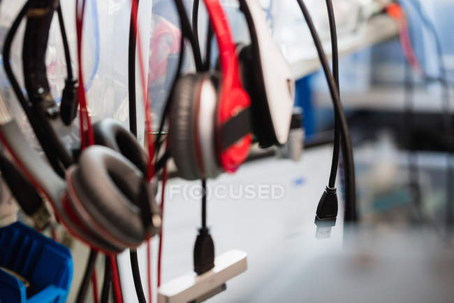 Various data cables and headphones hanging in a repair centre — Stock Photo