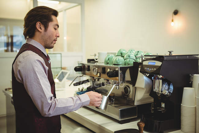 Man preparing coffee in coffee machine at coffee shop — Stock Photo