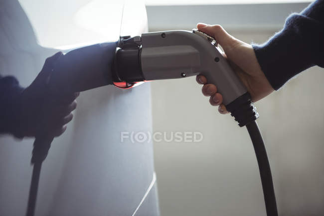 Крупним планом чоловічий автомобіль для зарядки рук на зарядній станції електромобіля — стокове фото
