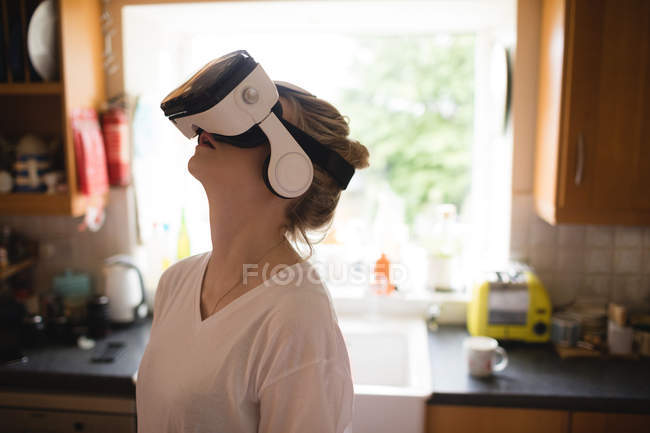 Mulher usando headset realidade virtual em casa — Fotografia de Stock