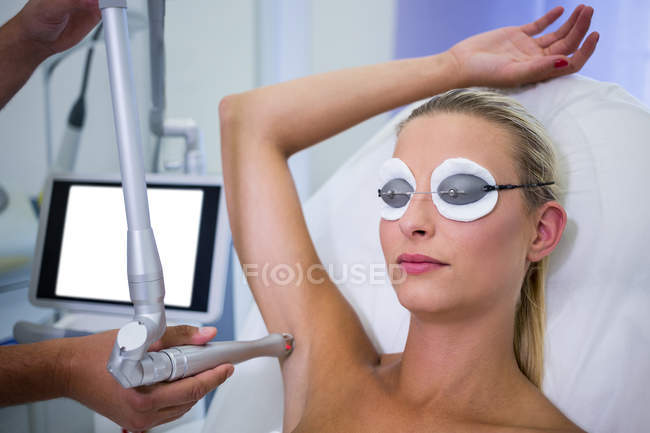 Dermatologista removendo o cabelo da axila paciente no salão de beleza — Fotografia de Stock
