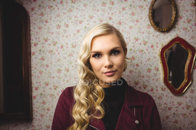 Retrato de una hermosa mujer de pie contra la pared - foto de stock