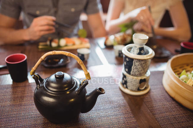 Teekanne und Becher auf dem Esstisch im Restaurant — Stockfoto