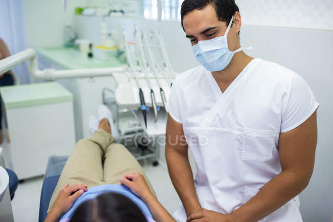 Medico indossando maschera chirurgica con paziente femminile in clinica — Foto stock