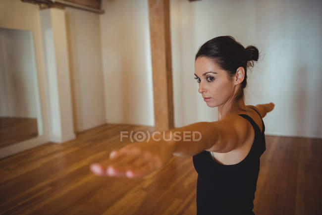 Woman practicing yoga in fitness studio — Stock Photo