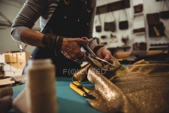 Meados de seção de artesã cortando couro na oficina — Fotografia de Stock