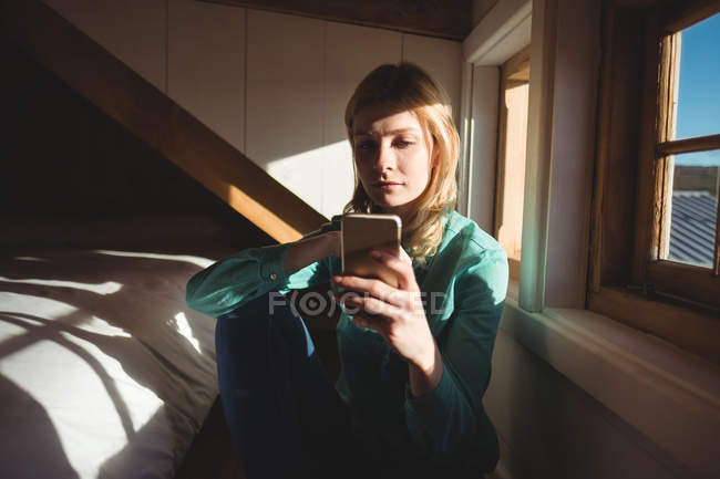 Bella donna che utilizza il telefono cellulare in camera da letto a casa — Foto stock