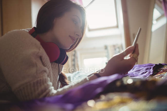 Beautiful woman using digital tablet on bed at home — Stock Photo