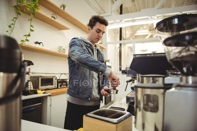 Uomo che preme caffè con manomissione in portafilter in caffetteria — Foto stock