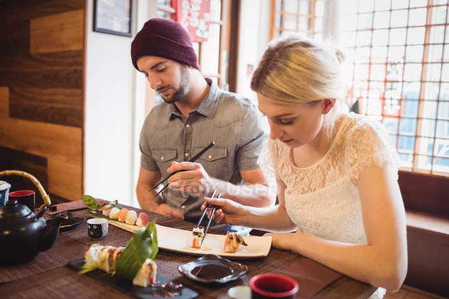 Couple eating sushi in restaurant — Stock Photo
