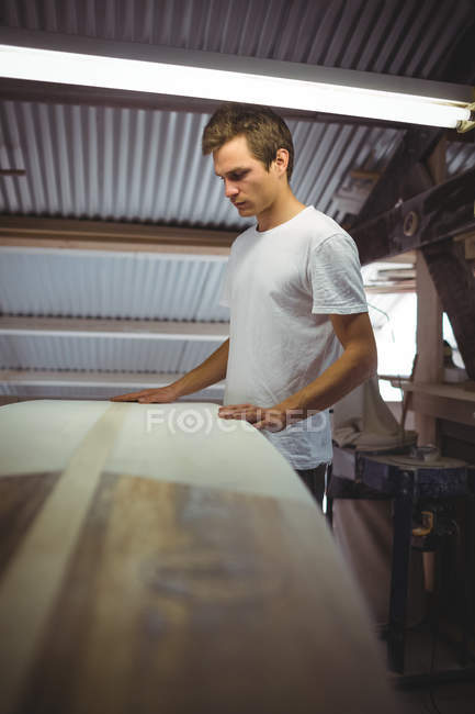 Man making surfboard in workshop interior — Stock Photo