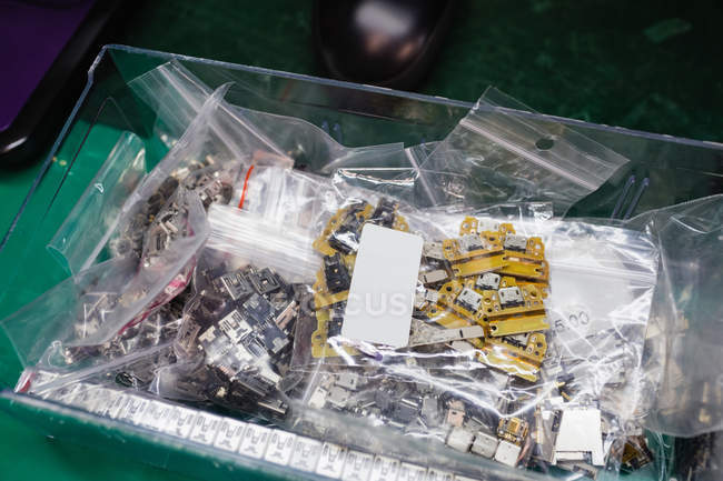 Крупный план различных электронных компонентов в пластиковых коробках — стоковое фото