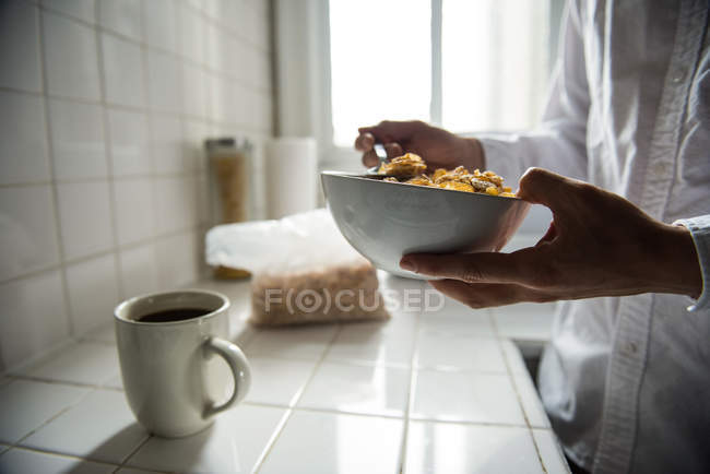 Средняя часть человека завтракает на кухне дома — стоковое фото