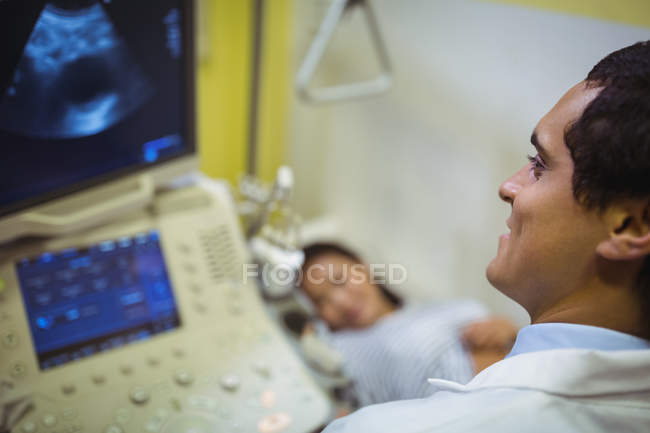 Arzt schaut sich Ultraschallgerät im Krankenhaus an — Stockfoto