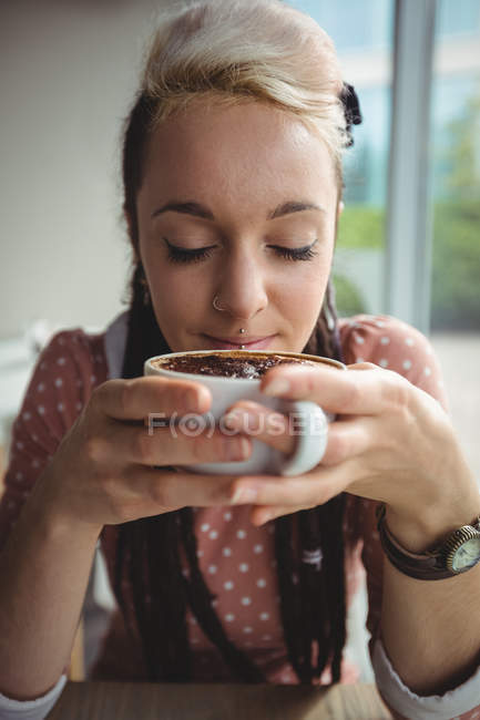 Жінка має чашку кави в кафе — стокове фото