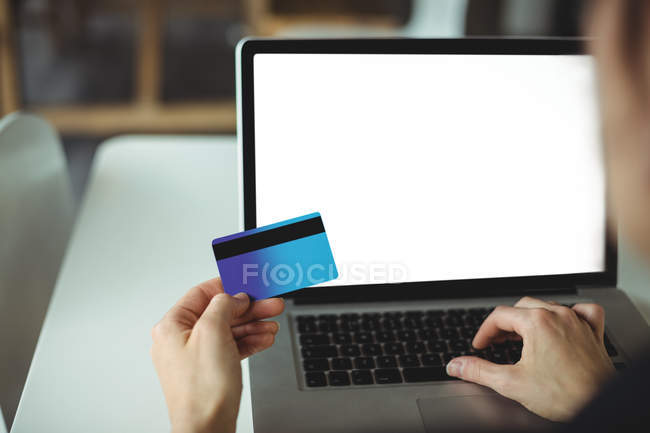 Frau bezahlt online mit Laptop und Kreditkarte im Café — Stockfoto