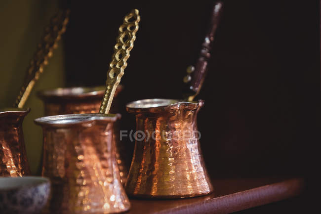 Close-up de recipientes de bronze dispostos na prateleira — Fotografia de Stock