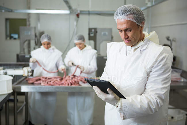 Técnico usando tablet digital na fábrica de carne — Fotografia de Stock