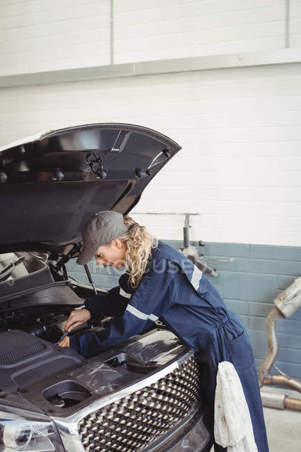 Feminino mecânico de manutenção de carro na garagem de reparação — Fotografia de Stock