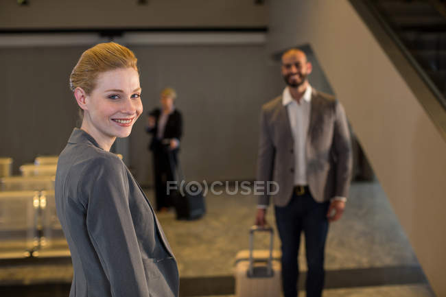 Business people walking with luggage at airport terminal — Stock Photo