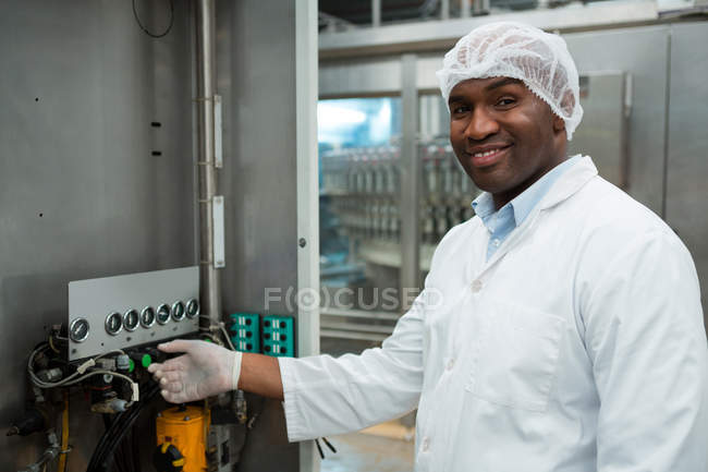 Portrait of confident male worker operating machine in juice factory — Stock Photo
