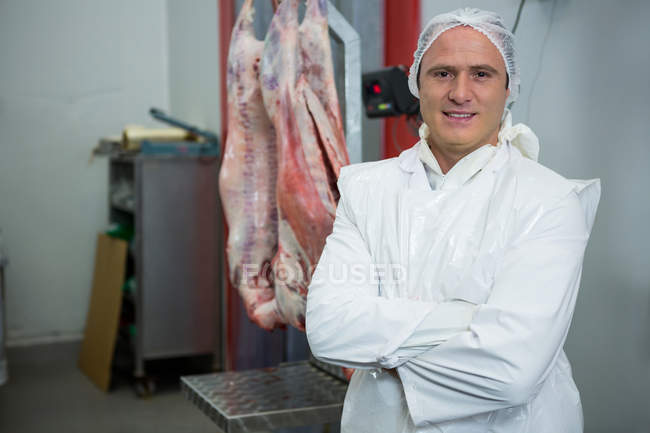 Ritratto di macellaio in piedi con le braccia incrociate in fabbrica di carne — Foto stock