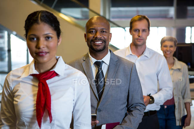 Портрет женского персонала и пассажиров, стоящих в терминале аэропорта — стоковое фото
