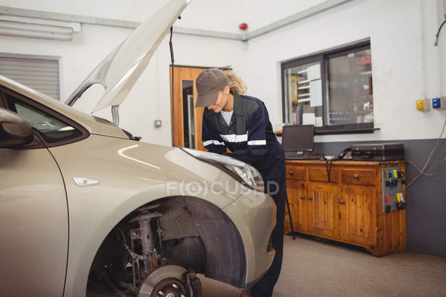 Mecánica femenina servicio de coches en el garaje de reparación - foto de stock