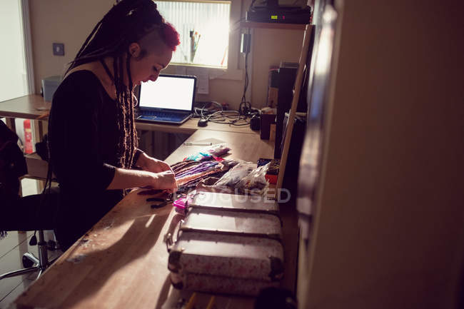 Cabeleireiro feminino trabalhando na mesa na loja dreadlocks — Fotografia de Stock