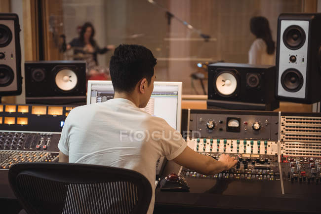 Ingeniero de audio usando mezclador de sonido en estudio de grabación - foto de stock