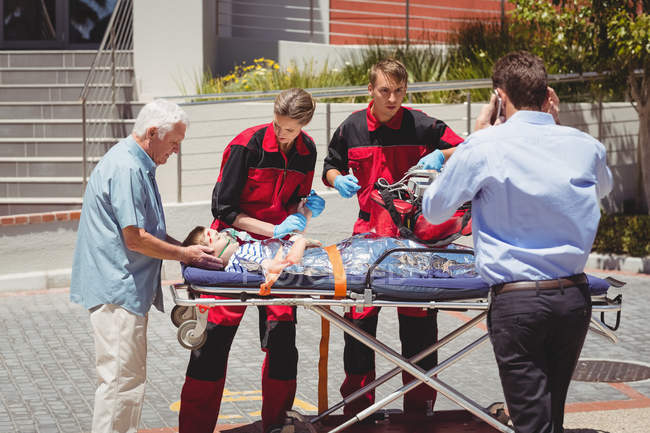 I paramedici esaminano ragazzo ferito sulla strada — Foto stock