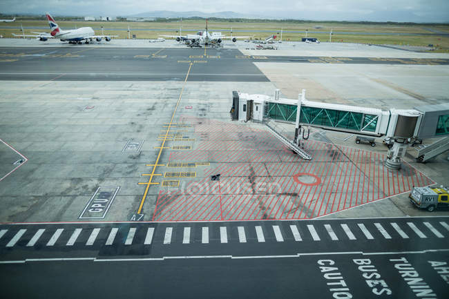 Boarding bridge docked with airplane in airport — Stock Photo