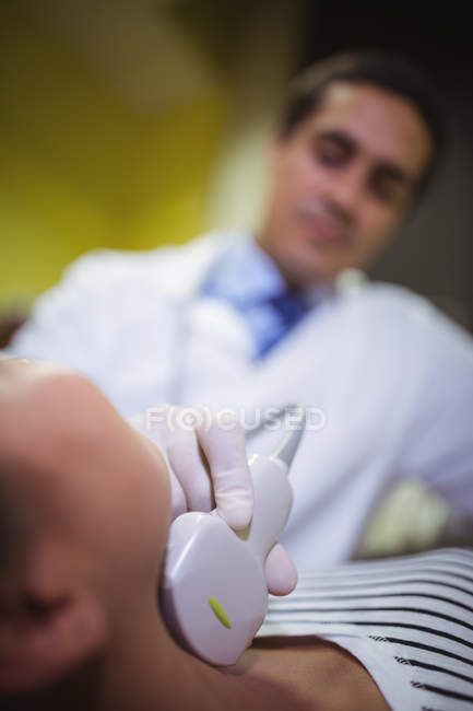 Close-up of female patient receiving a ultrasound  scan on the neck — Stock Photo