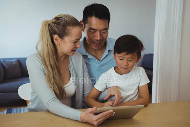 Семья с помощью цифрового планшета в гостиной на дому — стоковое фото