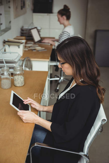 Представительница женского бизнеса с помощью цифрового планшета в офисе — стоковое фото