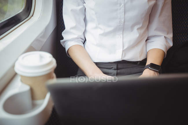 Metà sezione di donna d'affari utilizzando il computer portatile durante il viaggio — Foto stock