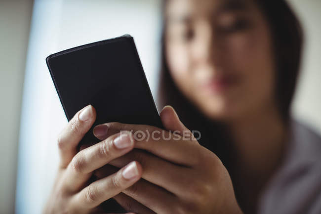 Nahaufnahme einer Geschäftsfrau mit Handy im Büro — Stockfoto