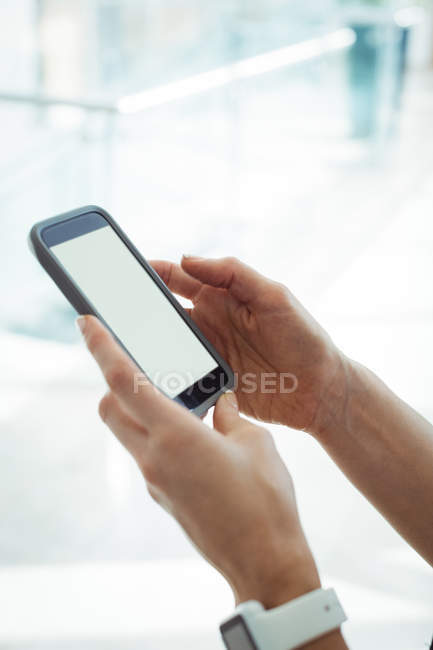 Hands of woman using mobile phone indoors — Stock Photo