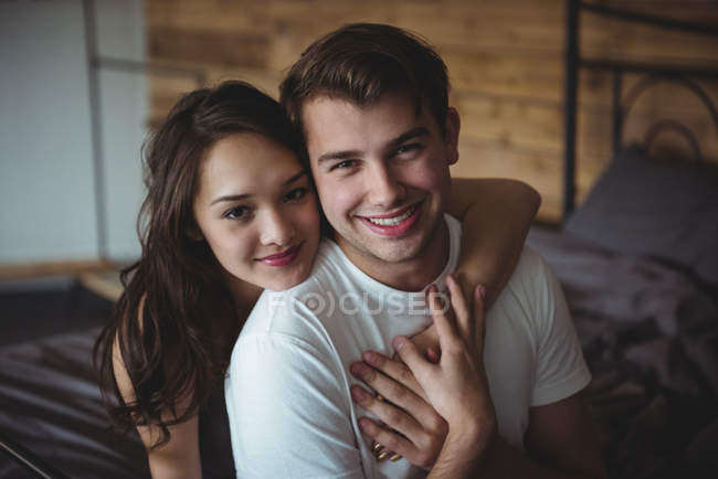 Portrait de couple souriant dans la chambre à coucher à la maison — Photo de stock