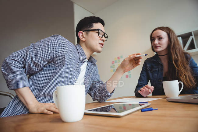 Executivos interagindo uns com os outros no escritório — Fotografia de Stock