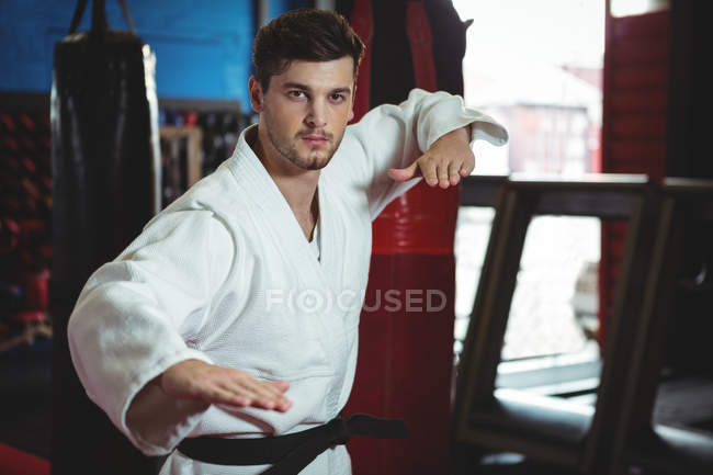 Portrait of karate player performing karate stance in fitness studio — Stock Photo