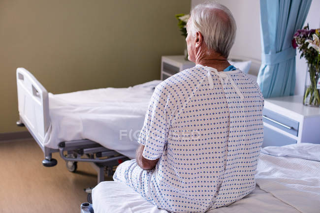 Продуманий чоловік старший пацієнт сидить у палаті в лікарні — стокове фото