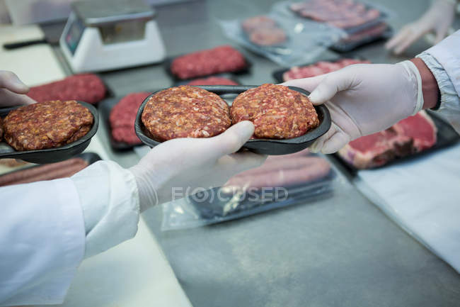 Macellai confezionare carne macinata in un vassoio di imballaggio di plastica in fabbrica di carne — Foto stock