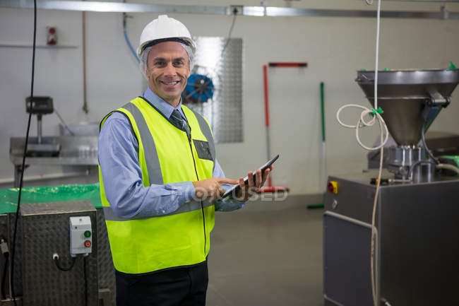 Porträt eines lächelnden Technikers mit digitalem Tablet in der Fleischfabrik — Stockfoto