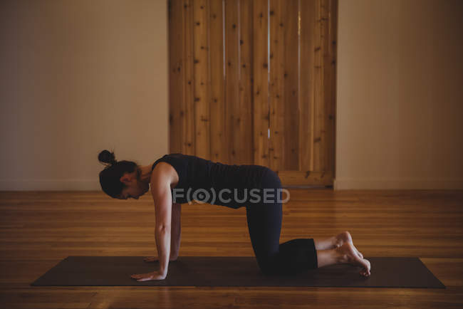 Femme pratiquant le yoga dans un studio de fitness — Photo de stock