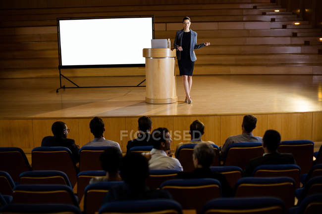 Female business executive giving a speech at conference center — Stock Photo