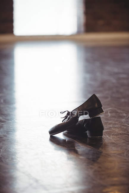 Пара танцевальных туфель на деревянном полу в танцевальной студии — стоковое фото