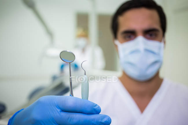 Крупним планом рука тримає зубні інструменти — стокове фото
