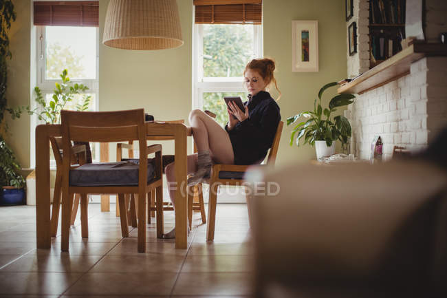 Женщина с помощью цифрового планшета дома — стоковое фото