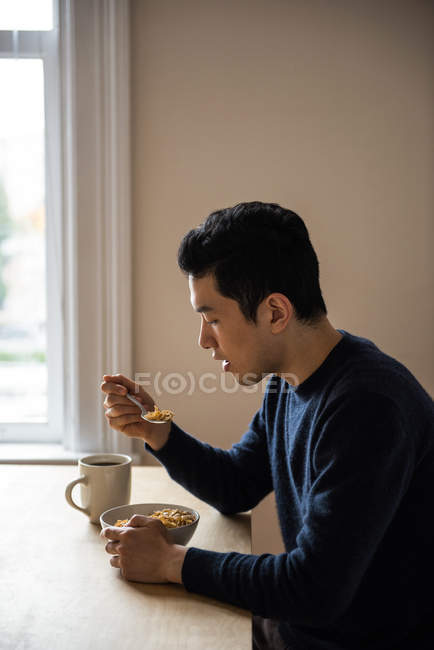 Uomo con una ciotola di cereali a casa — Foto stock